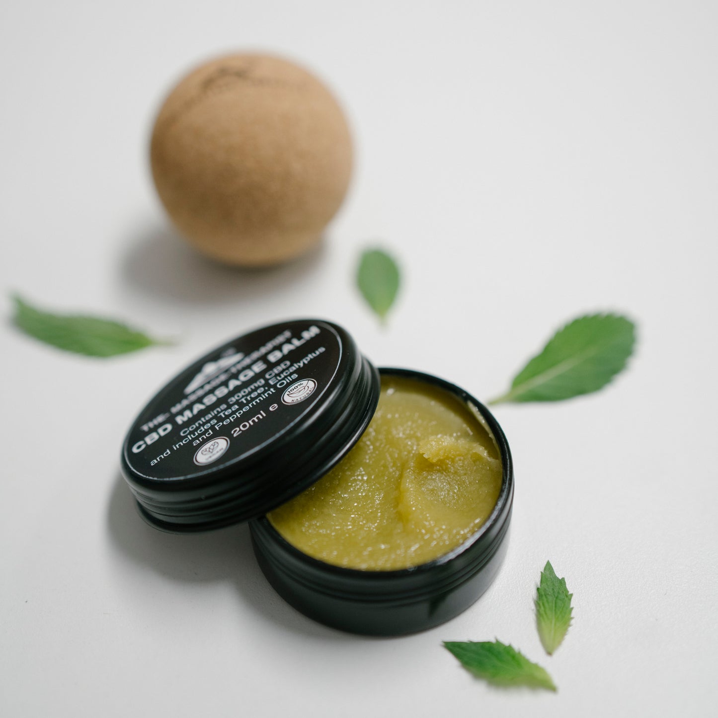 All natural and vegan pain relief CBD massage balm open and cork massage ball behind