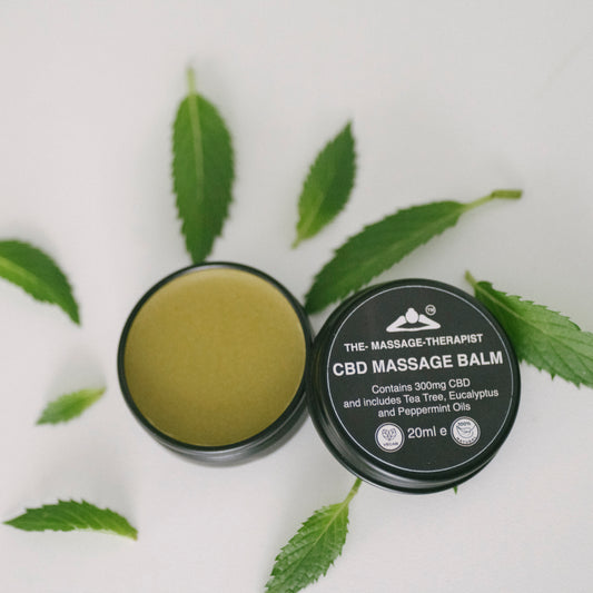 CBD massage balm with lid off, showing green minty balm